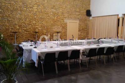 Salle à manger lumineuse avec table en bois, chaises colorées, cuisine ouverte et décoration sobre.