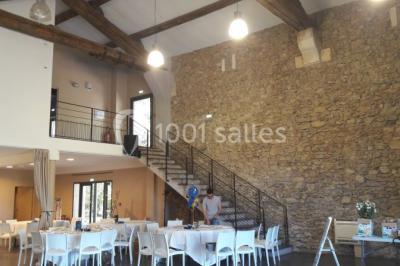 Salle à manger lumineuse avec table en bois, chaises colorées, cuisine ouverte et décoration sobre.