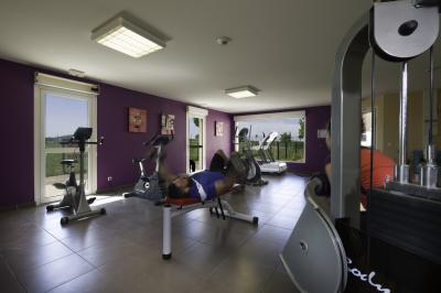 Salle à manger lumineuse avec table en bois, chaises colorées, cuisine ouverte et décoration sobre.