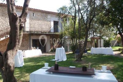 Salle à manger lumineuse avec table en bois, chaises colorées, cuisine ouverte et décoration sobre.