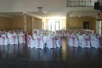 Salle à manger lumineuse avec table en bois, chaises colorées, cuisine ouverte et décoration sobre.