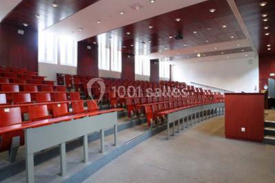 Salle de restauration lumineuse avec de grandes baies vitrées, tables orange et bois, et chaises assorties.