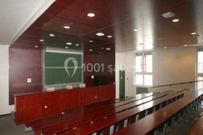 Salle de restauration lumineuse avec de grandes baies vitrées, tables orange et bois, et chaises assorties.