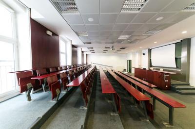Salle de restauration lumineuse avec de grandes baies vitrées, tables orange et bois, et chaises assorties.