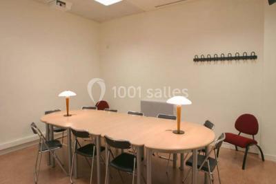 Salle de restauration lumineuse avec de grandes baies vitrées, tables orange et bois, et chaises assorties.