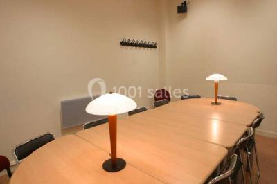 Salle de restauration lumineuse avec de grandes baies vitrées, tables orange et bois, et chaises assorties.