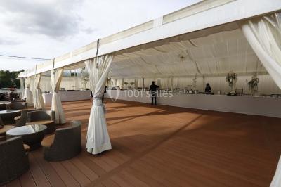Salle de bain avec une cabine de douche moderne, un banc en bois intégré, deux vasques noires et une fenêtre avec stores.