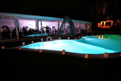 Salle de bain avec une cabine de douche moderne, un banc en bois intégré, deux vasques noires et une fenêtre avec stores.