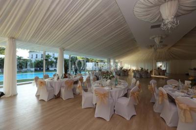 Salle de bain avec une cabine de douche moderne, un banc en bois intégré, deux vasques noires et une fenêtre avec stores.