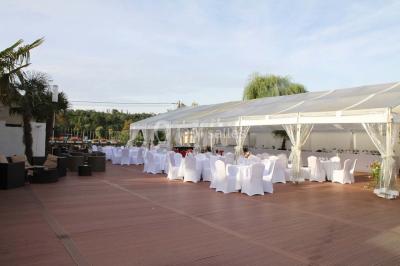 Salle de bain avec une cabine de douche moderne, un banc en bois intégré, deux vasques noires et une fenêtre avec stores.
