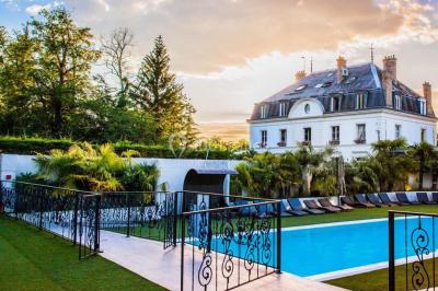 Salle de bain avec une cabine de douche moderne, un banc en bois intégré, deux vasques noires et une fenêtre avec stores.