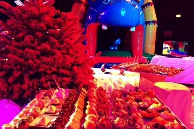 Salle lumineuse avec tables et chaises modernes, sol en moquette, cloison en bois et tapis rouge au centre.