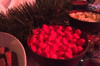 Salle lumineuse avec tables et chaises modernes, sol en moquette, cloison en bois et tapis rouge au centre.