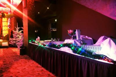 Salle lumineuse avec tables et chaises modernes, sol en moquette, cloison en bois et tapis rouge au centre.