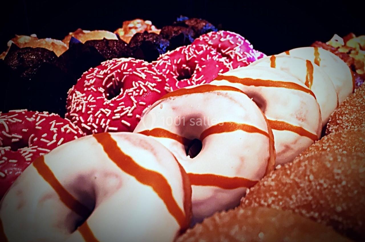 Assortiment de donuts colorés avec glaçages variés, incluant des décorations au sucre et des traits de caramel.