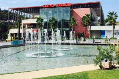 Salle lumineuse avec tables et chaises modernes, sol en moquette, cloison en bois et tapis rouge au centre.