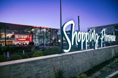 Salle lumineuse avec tables et chaises modernes, sol en moquette, cloison en bois et tapis rouge au centre.