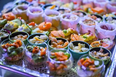 Salle lumineuse avec tables et chaises modernes, sol en moquette, cloison en bois et tapis rouge au centre.
