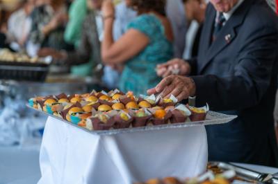 Salle lumineuse avec tables et chaises modernes, sol en moquette, cloison en bois et tapis rouge au centre.