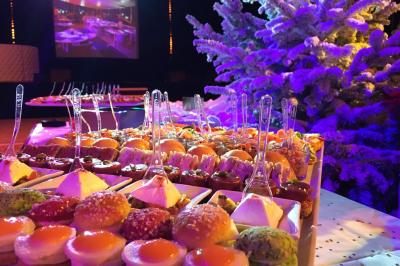 Salle lumineuse avec tables et chaises modernes, sol en moquette, cloison en bois et tapis rouge au centre.