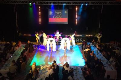 Salle lumineuse avec tables et chaises modernes, sol en moquette, cloison en bois et tapis rouge au centre.