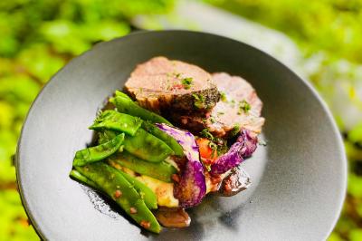 Salle lumineuse avec tables et chaises modernes, sol en moquette, cloison en bois et tapis rouge au centre.