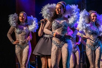Salle lumineuse avec tables et chaises modernes, sol en moquette, cloison en bois et tapis rouge au centre.