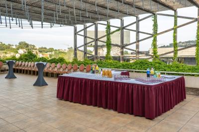 Salle lumineuse avec tables et chaises modernes, sol en moquette, cloison en bois et tapis rouge au centre.