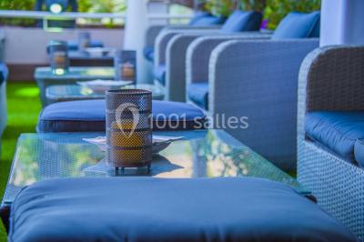 Salle lumineuse avec tables et chaises modernes, sol en moquette, cloison en bois et tapis rouge au centre.