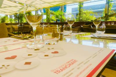Salle lumineuse avec tables et chaises modernes, sol en moquette, cloison en bois et tapis rouge au centre.
