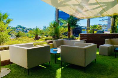 Salle lumineuse avec tables et chaises modernes, sol en moquette, cloison en bois et tapis rouge au centre.