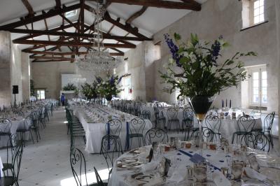 Miniature Location salle Granzay-Gript (Deux-Sèvres) - Château La Bone #10 Un couple de mariés s'embrasse devant une voiture ancienne stationnée dans une cour ensoleillée.