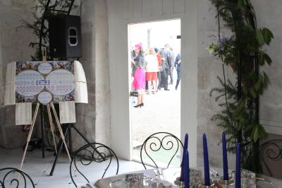 Miniature Location salle Granzay-Gript (Deux-Sèvres) - Château La Bone #12 Un couple de mariés s'embrasse devant une voiture ancienne stationnée dans une cour ensoleillée.