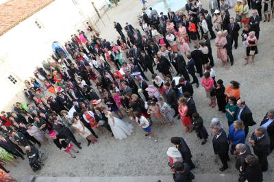 Miniature Location salle Granzay-Gript (Deux-Sèvres) - Château La Bone #14 Un couple de mariés s'embrasse devant une voiture ancienne stationnée dans une cour ensoleillée.