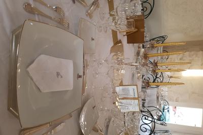 Miniature Location salle Granzay-Gript (Deux-Sèvres) - Château La Bone #17 Un couple de mariés s'embrasse devant une voiture ancienne stationnée dans une cour ensoleillée.