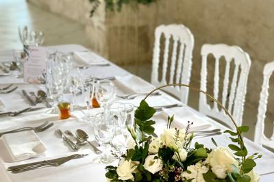 Miniature Location salle Granzay-Gript (Deux-Sèvres) - Château La Bone #18 Un couple de mariés s'embrasse devant une voiture ancienne stationnée dans une cour ensoleillée.