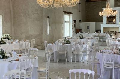 Miniature Location salle Granzay-Gript (Deux-Sèvres) - Château La Bone #21 Un couple de mariés s'embrasse devant une voiture ancienne stationnée dans une cour ensoleillée.