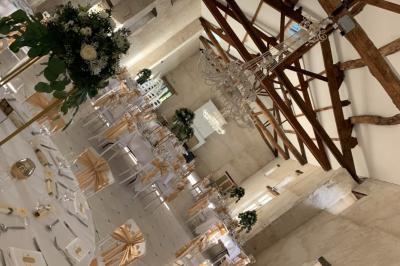 Miniature Location salle Granzay-Gript (Deux-Sèvres) - Château La Bone #7 Un couple de mariés s'embrasse devant une voiture ancienne stationnée dans une cour ensoleillée.