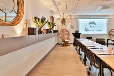 Salle de restaurant lumineuse avec mobilier élégant, banquettes vertes, tables en bois et bar moderne.