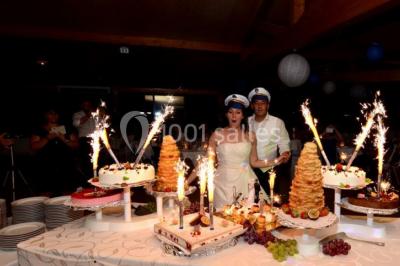 Des animatrices en jupes hawaïennes dansent devant un groupe d'enfants et d'adultes près d'une piscine extérieure.