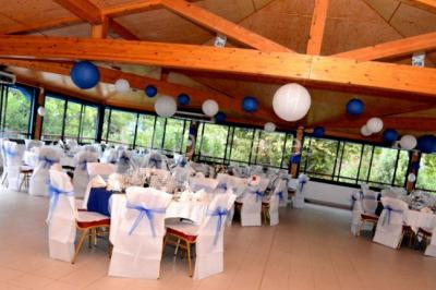 Des animatrices en jupes hawaïennes dansent devant un groupe d'enfants et d'adultes près d'une piscine extérieure.