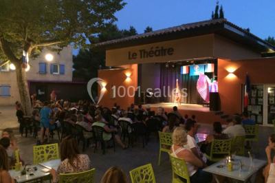 Des animatrices en jupes hawaïennes dansent devant un groupe d'enfants et d'adultes près d'une piscine extérieure.