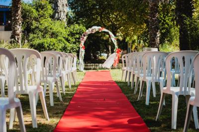 Des animatrices en jupes hawaïennes dansent devant un groupe d'enfants et d'adultes près d'une piscine extérieure.