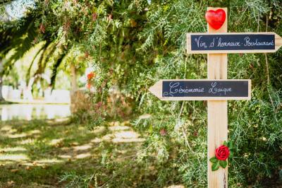 Des animatrices en jupes hawaïennes dansent devant un groupe d'enfants et d'adultes près d'une piscine extérieure.