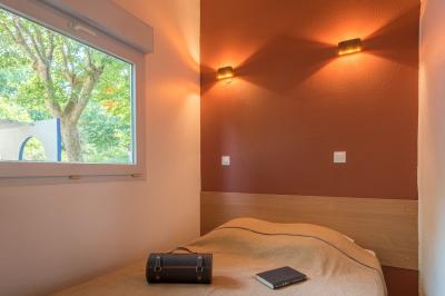 Des animatrices en jupes hawaïennes dansent devant un groupe d'enfants et d'adultes près d'une piscine extérieure.