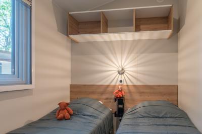 Des animatrices en jupes hawaïennes dansent devant un groupe d'enfants et d'adultes près d'une piscine extérieure.