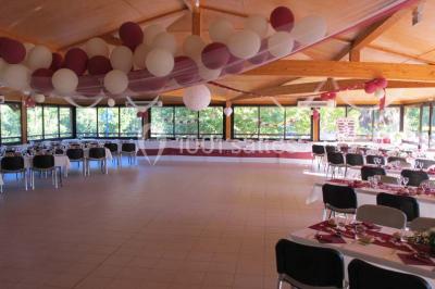Des animatrices en jupes hawaïennes dansent devant un groupe d'enfants et d'adultes près d'une piscine extérieure.