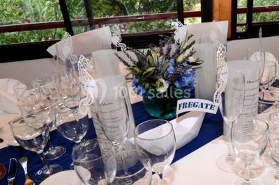 Des animatrices en jupes hawaïennes dansent devant un groupe d'enfants et d'adultes près d'une piscine extérieure.