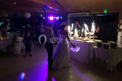 Des animatrices en jupes hawaïennes dansent devant un groupe d'enfants et d'adultes près d'une piscine extérieure.