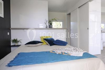 Des animatrices en jupes hawaïennes dansent devant un groupe d'enfants et d'adultes près d'une piscine extérieure.